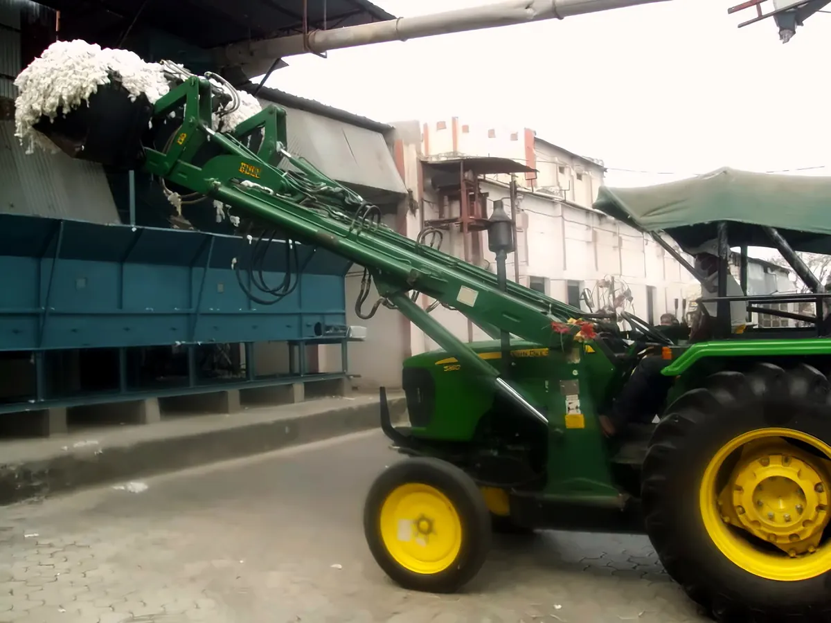 A loader feeding seed cotton into the processing line